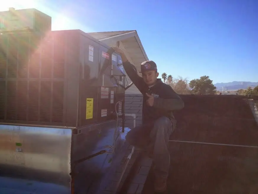 HVAC technician performing AC Tune-Up on a rooftop unit in Depew